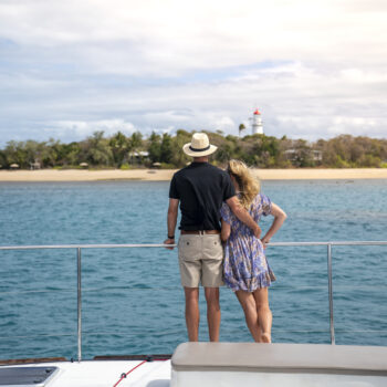 Man and woman looking at Low Isles from a yacht off the coast of Port Douglas